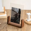 A walnut wood and acrylic photo frame displaying a black and white photograph of a woman.