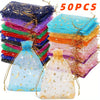 A stack of colorful organza drawstring bags featuring moon and star patterns, with a loose bag in the foreground.