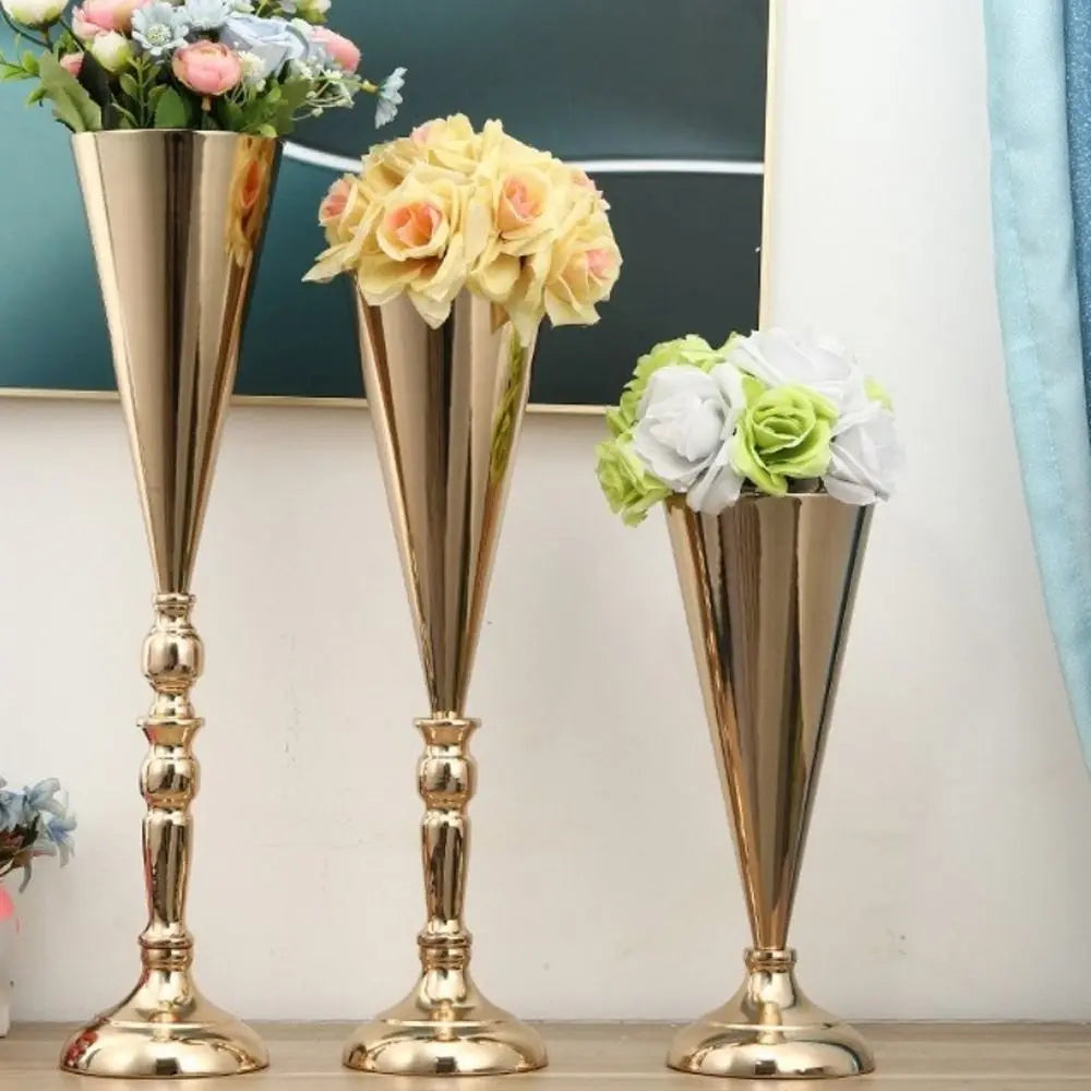 Three tall, elegant golden silver wedding flower vases holding pink, yellow, and white roses.