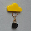 A gold-colored magnetic cloud key hanger with a yellow cloud shape and a black charm.