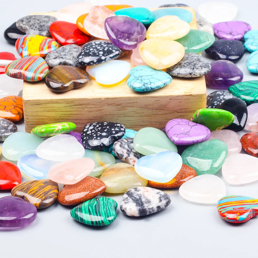 A collection of heart-shaped amethyst crystal stones in various colors and shades arranged on a wooden surface.
