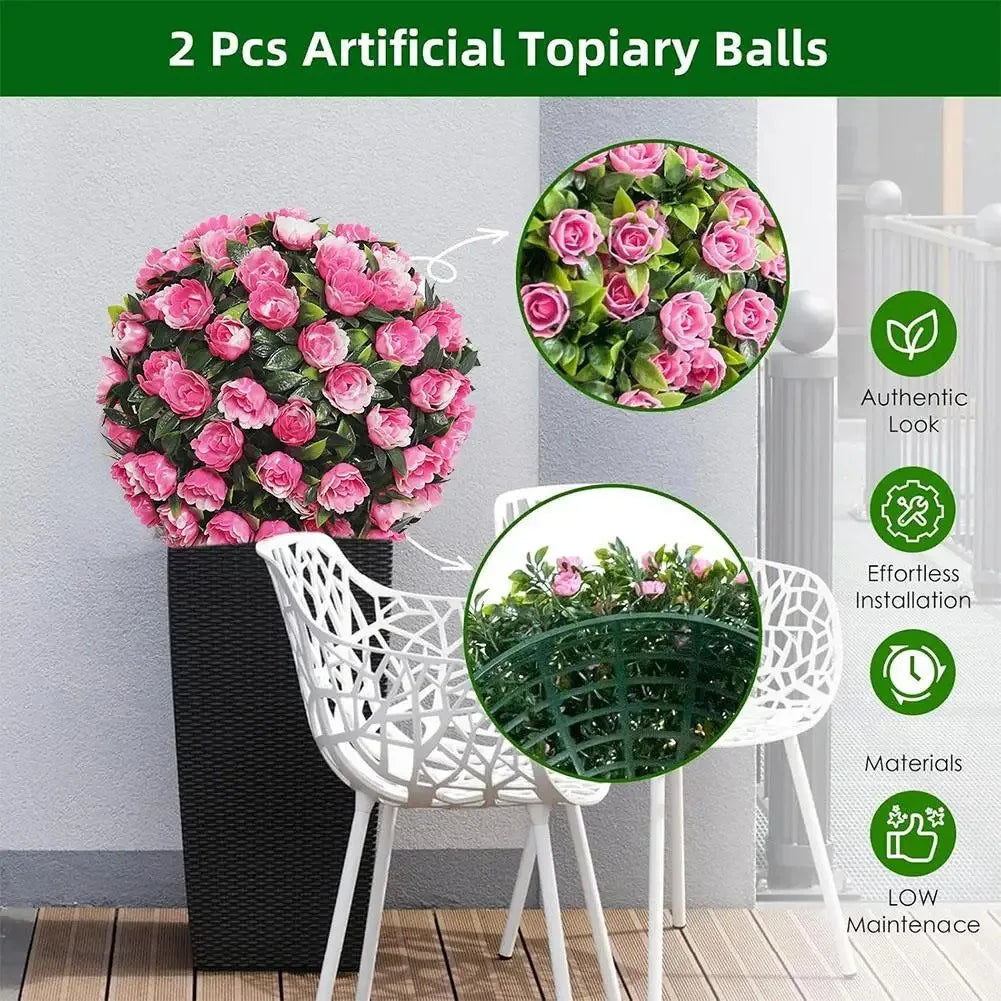 Two artificial topiary balls of pink roses displayed on a table with white chairs.