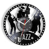 A black wall clock face featuring silhouettes of musicians and a saxophone, with the name 'AZZ' below.