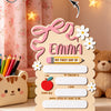 A personalized wooden sign for a child named Emma featuring a daisy bow and space for details like her first day, teacher, ag