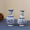 Blue and white ceramic flower vase with intricate floral patterns on a gray surface.