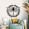 Elegant black dragonfly metal wall art hanging on a white wall next to a light blue armchair