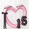 Pink heart-shaped balloon decoration with Happy Birthday text and the number 15