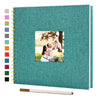 A teal linen cover scrapbook album with a square photo insert and a gold-colored pen.