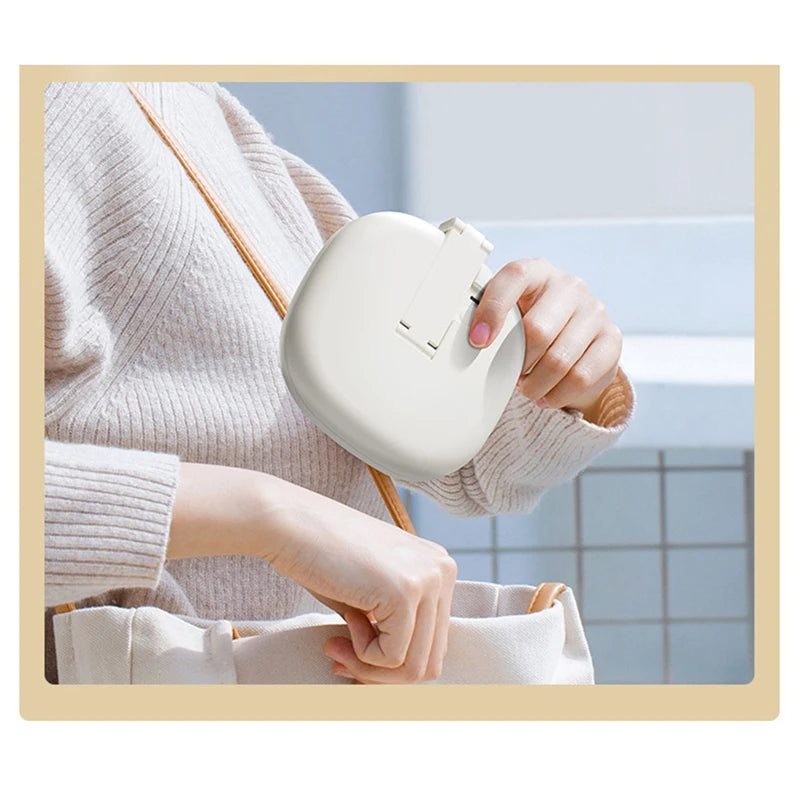 A person holds a white foldable LED makeup mirror with magnification in a light-colored sweater.