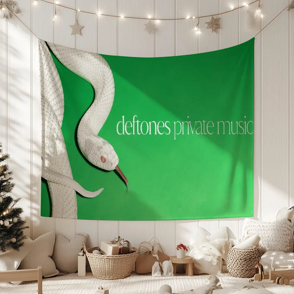 A green fabric tapestry featuring a white snake design, displayed on a light-colored wall.