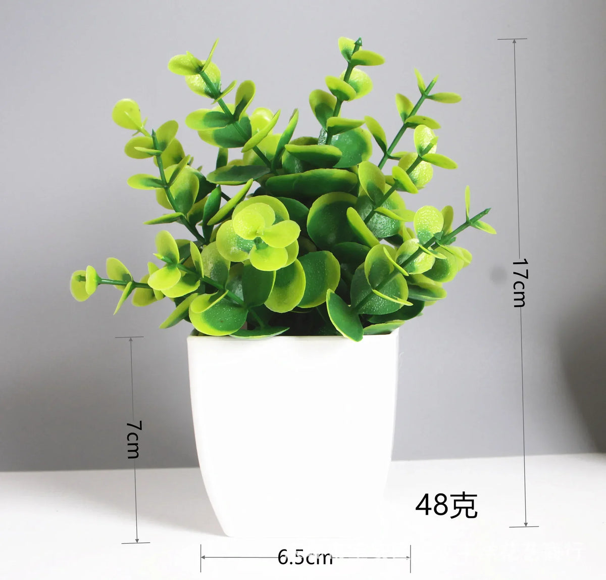 A potted artificial bonsai plant with bright green eucalyptus leaves in a white cylindrical pot.
