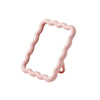 A pink wavy frame makeup mirror with a stand.