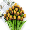A bouquet of artificial yellow and brown tulips with green stems for decoration.