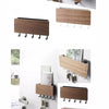 A set of bamboo wall-mounted key racks and hooks for organizing keys.