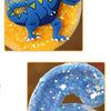 A blue dinosaur shaped number six candle decorated with glitter and yellow background.