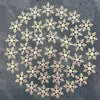 A pattern of white and pink frosted snowflakes scattered across a denim background.