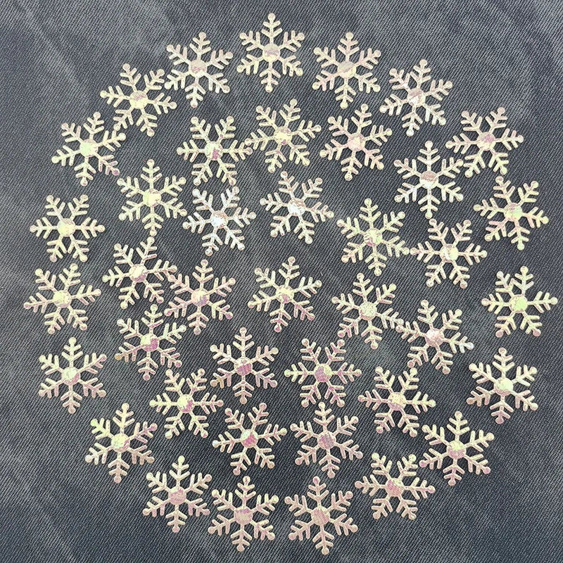 A pattern of white and pink frosted snowflakes scattered across a denim background.