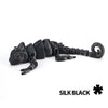 A black articulated dragon lizard figurine with textured scales.