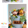 A tiered cake decorated with jungle animal toppers including a lion, elephant, and tiger in earthy tones.