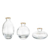 A set of three minimalist clear glass bud vases, varying in size and shape.