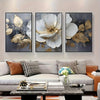 A set of three modern abstract floral wall art prints featuring white and gold leaves on a gray background.