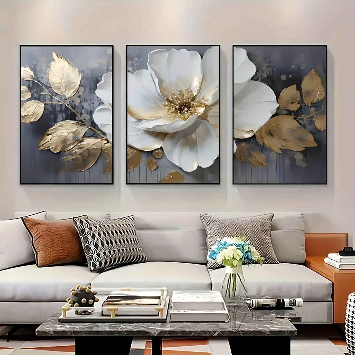A set of three modern abstract floral wall art prints featuring white and gold leaves on a gray background.