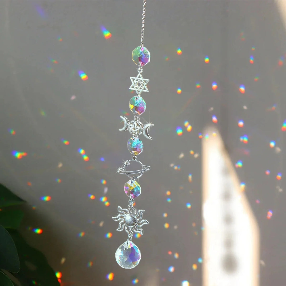 A silver crystal wind chime pendant featuring a rainbow sun catcher design with various celestial elements.