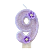 A purple sparkling number nine candle decorated with small purple flowers.