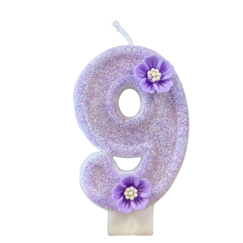 A purple sparkling number nine candle decorated with small purple flowers.