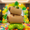 Two standing foil balloons shaped like capybaras and a turtle in various shades of green and yellow for party decor