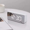 A white LED digital alarm clock with a display showing 12:30 on a white surface.