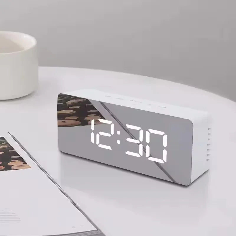 A white LED digital alarm clock with a display showing 12:30 on a white surface.