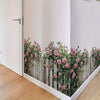 A white door features a Bohemian floral wooden fence wall decal with pink roses and green foliage.