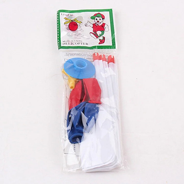 A clear plastic bag containing a red and yellow whistling balloon helicopter toy with various parts.