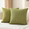 A set of two olive green linen pillows resting on a white textured surface.