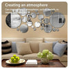A wall decor set featuring various round acrylic mirrors in silver and gold tones displayed above a beige sofa.