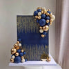 A set of blue, white, and gold ball cake toppers displayed on a dark blue square background.