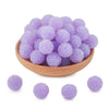 A wooden bowl filled with a set of ten purple textured resin beads for jewelry making
