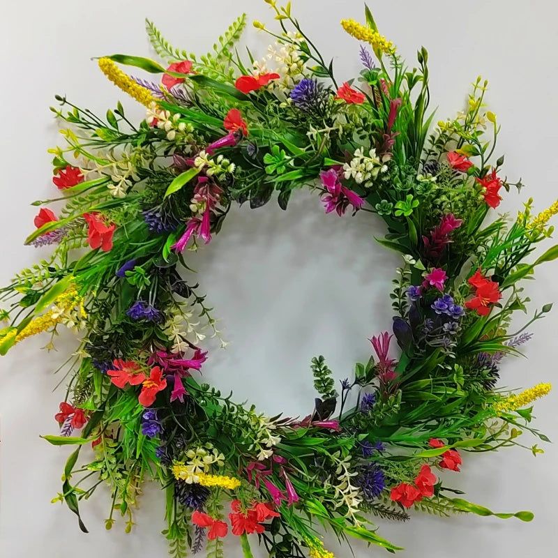 A wreath of artificial wildflowers featuring red, purple, yellow, and white flowers and green foliage for spring and summer d