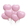 A bunch of pink and white checkered heart-shaped foil balloons tied together with strings.