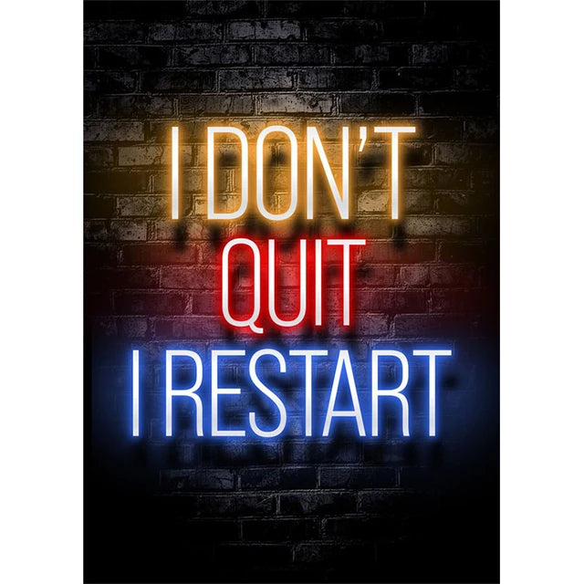 Texto brillante en neón sobre una pared de ladrillo oscuro dice 'I DON'T QUIT I RESTART' en amarillo, rojo y azul.