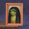 A framed photograph of a green frog with long black hair inside an orange wooden frame.