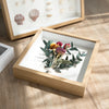 A wooden shadow box photo frame displaying dried floral arrangements and seashells.