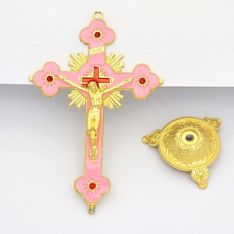 Antique-style crucifix figurine featuring a gold cross and pink floral accents on a stand.