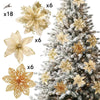 A set of six glittered artificial gold flowers with clips displayed next to a decorated Christmas tree.