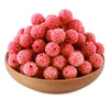 A pile of bright pink textured resin beads for jewelry making in a wooden bowl.