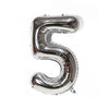 A metallic silver foil balloon shaped like the number five.