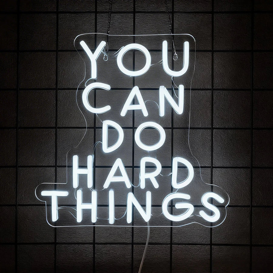A white neon sign on a dark background reads You Can Do Hard Things.