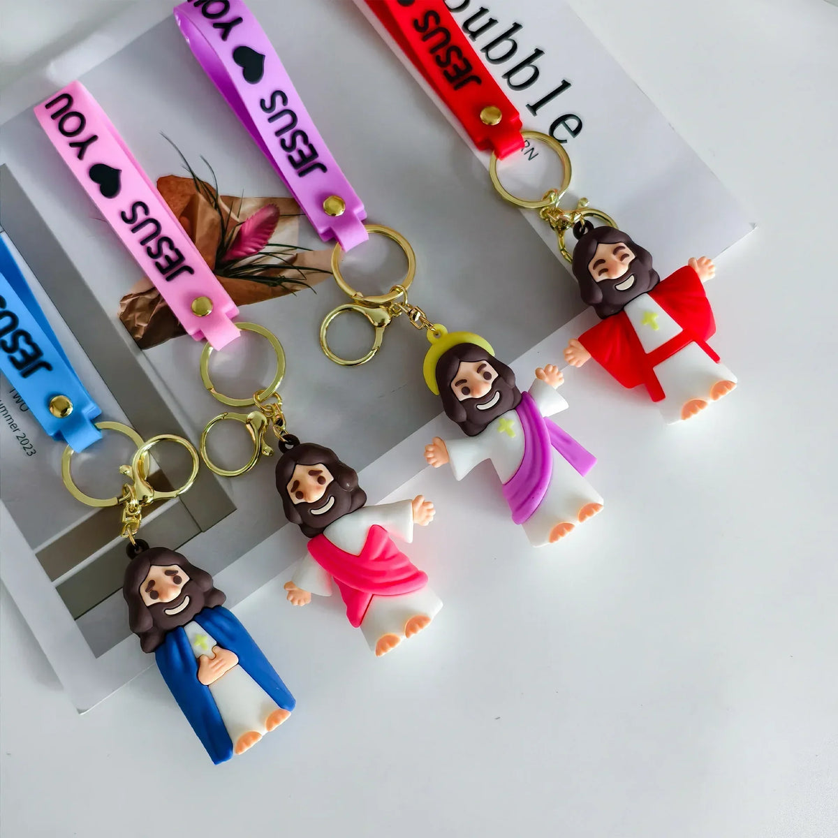 A set of cute silicone Jesus keychains featuring various colors and straps on a white background.