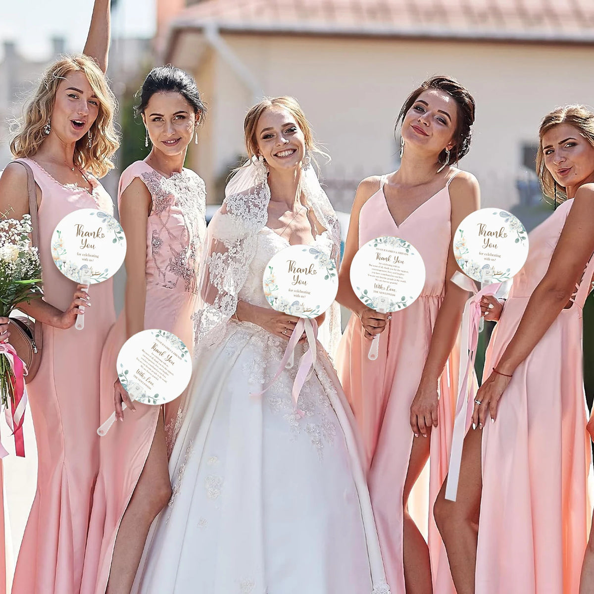 Five women in pink dresses holding thank you cards posing outdoors